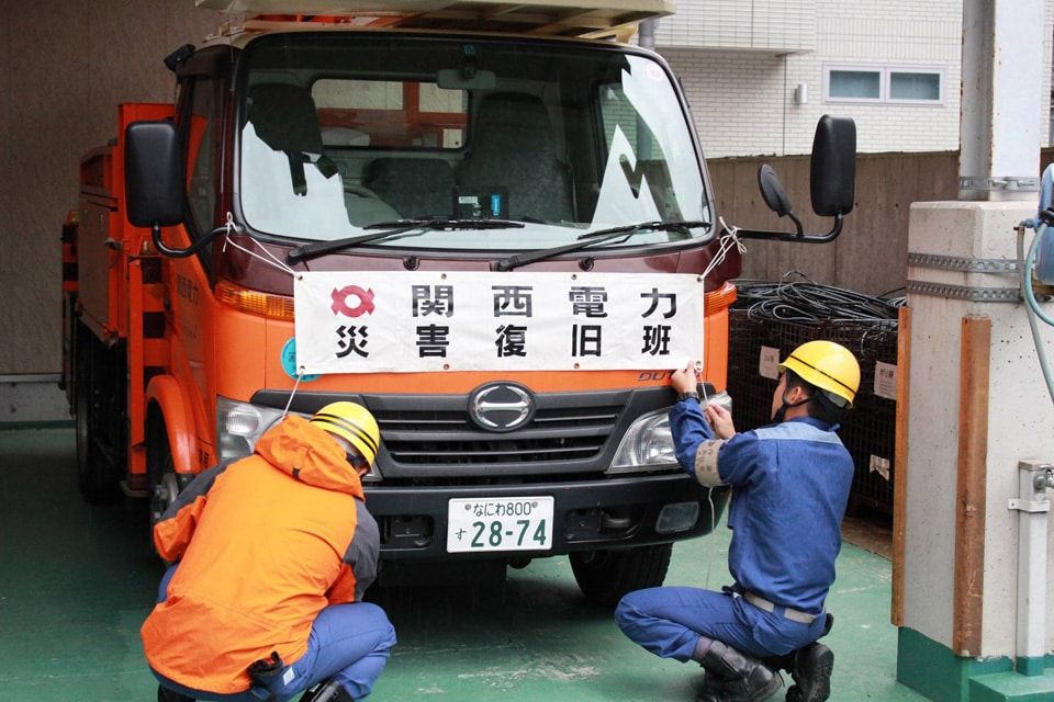 車両に横断幕を取り付ける作業員