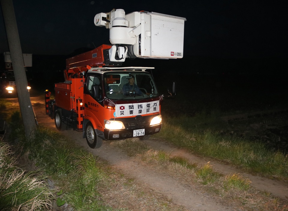 暗闇の中、次の現場に向かう当社車両