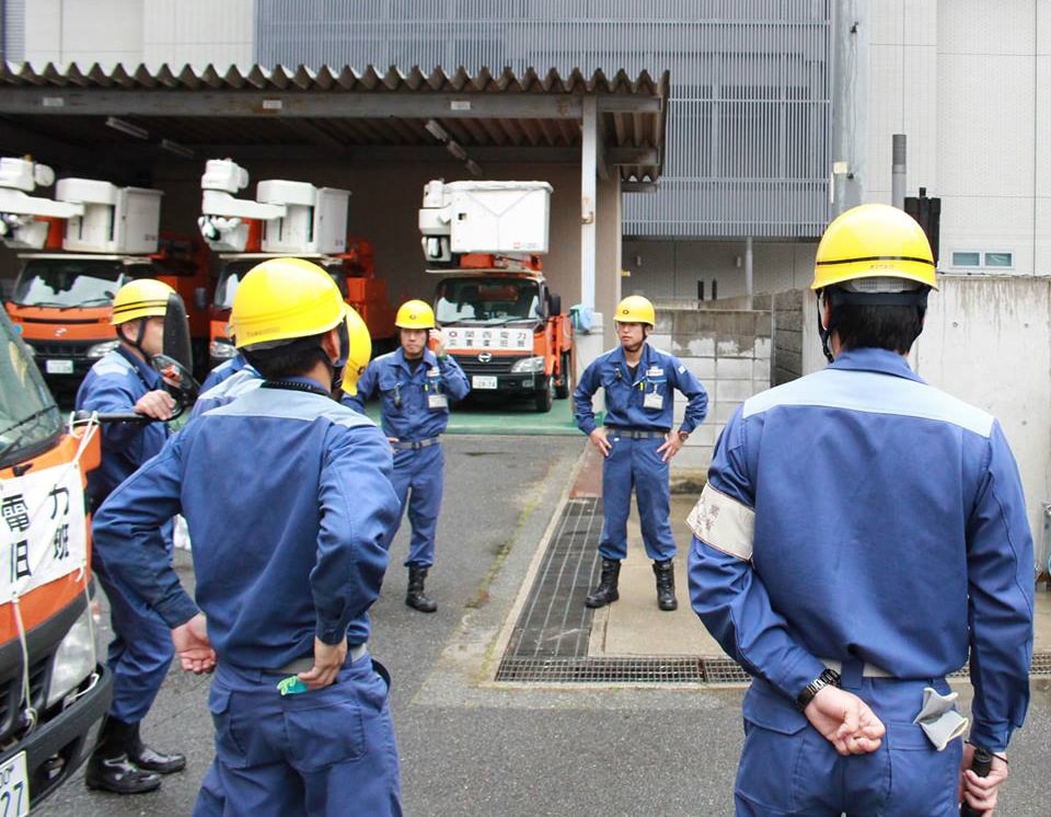 九州地方への出発前に円陣を組む作業員