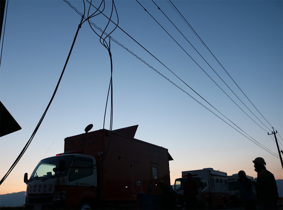 夕暮れの中、応急送電を行う高圧発電機車