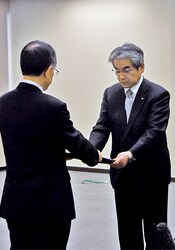 原子力規制委員会より許可証を受け取る森中原子力事業本部長代理(右)(東京・原子力規制委員会)