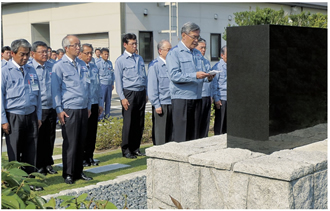 「安全の誓い」の石碑の前で、安全最優先の事業活動を誓う八木社長