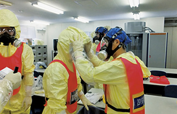 放射線防護服やマスクを着用した悪条件下を想定した消防ポンプ設置訓練