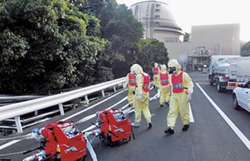 放射線防護服やマスクを着用した悪条件下を想定した消防ポンプ設置訓練