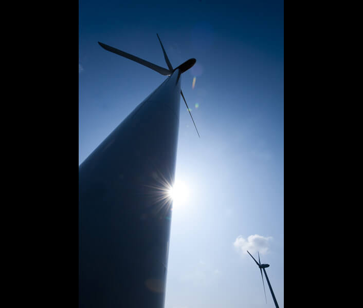 太陽に照らされるブレード（羽根）と風車タワー