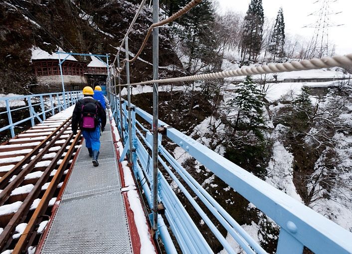 谷底が見える鉄橋を渡って荷物を運搬