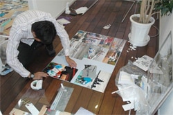 社内用記念パネル作成～心を込めて写真を貼り付ける大塚選手～